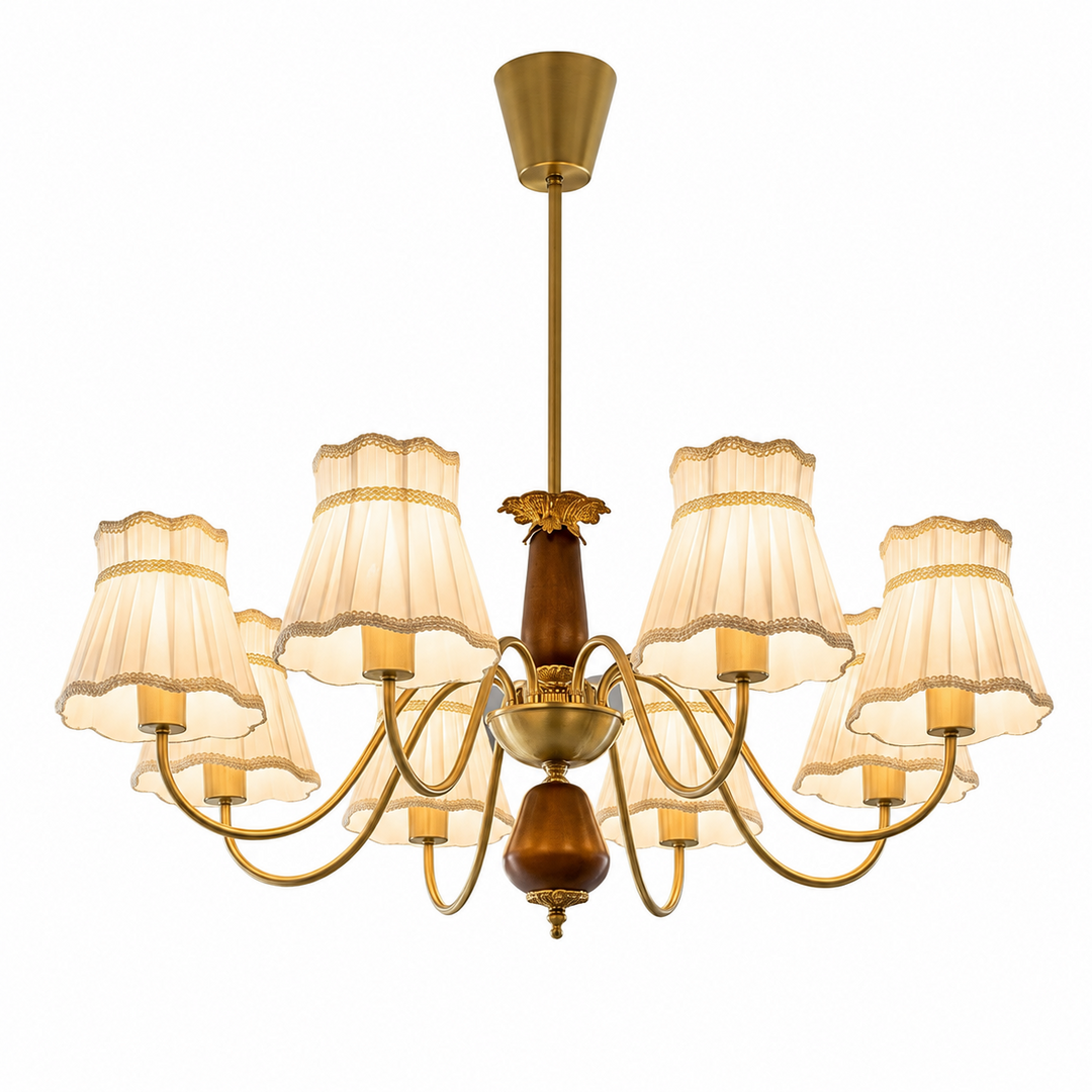 Chandelier with curved gold-toned arms, brown central accents, and cream pleated shades with decorative trim against a white background.